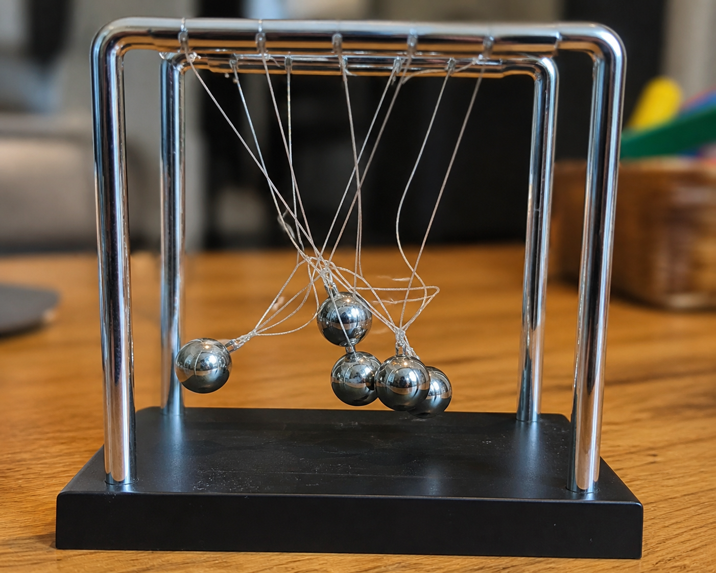 Tangled Newton’s cradle toy with twisted strings after a child tried to fix it